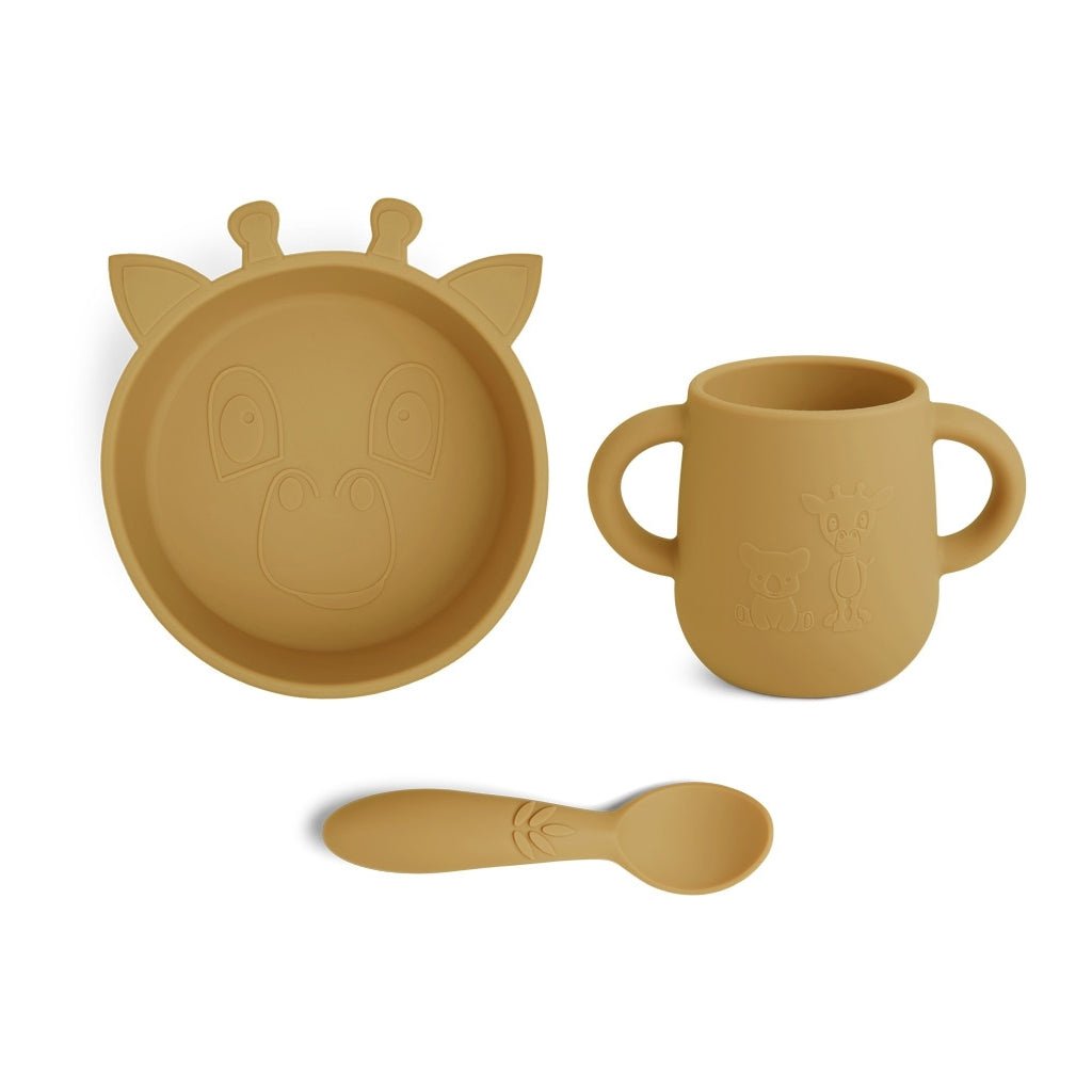 Siliconen eetset in kleur geel voor baby's eerste hapjes. De set bestaat uit 3 stuks: een diep bord, beker met handvat en een lepel, allemaal met een motief van een schattige giraf.